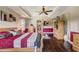 Spacious main bedroom featuring a tray ceiling, ceiling fan, hardwood floors, and a large bed at 3656 Heirloom Rose Pl, Oviedo, FL 32766