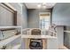 Bright home office features large window, white desk, ample storage shelves, and neutral decor at 3656 Heirloom Rose Pl, Oviedo, FL 32766