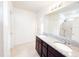 Modern bathroom with double sinks, granite countertops, dark wood cabinets, and a walk-in shower with tile surround at 398 Citrus Isle Loop, Davenport, FL 33837