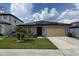 Attractive single-level home boasts solar panels, a manicured lawn, and a convenient two-car garage under a bright sky at 398 Citrus Isle Loop, Davenport, FL 33837