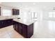 Open-concept kitchen featuring granite countertops, stainless steel appliances, island seating, and ample natural light at 398 Citrus Isle Loop, Davenport, FL 33837
