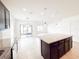 Open-concept kitchen boasts an island with granite counters, modern pendant lighting, and stainless appliances at 398 Citrus Isle Loop, Davenport, FL 33837