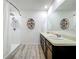 Bright bathroom with a double sink vanity, tiled shower and round decorative shelves at 3980 Gadwall Pl, Leesburg, FL 34748
