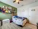 Bedroom featuring light green walls, a full size bed, and decorated shelves with toys at 3980 Gadwall Pl, Leesburg, FL 34748