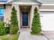 Inviting front entrance featuring a dark blue door, manicured greenery, and a well-lit porch offering curb appeal at 3980 Gadwall Pl, Leesburg, FL 34748