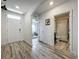 Bright hallway with a front door, bathroom doorway, wood laminate floors, and neutral paint at 3980 Gadwall Pl, Leesburg, FL 34748