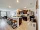 Bright kitchen with a center island featuring seating, dark wood cabinetry, stainless steel appliances, and wood-look floors at 3980 Gadwall Pl, Leesburg, FL 34748