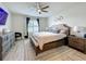 Bright main bedroom with a large window, ceiling fan, and a decorative headboard at 3980 Gadwall Pl, Leesburg, FL 34748