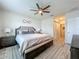 Bright main bedroom with a large window, ceiling fan, and an ensuite bathroom at 3980 Gadwall Pl, Leesburg, FL 34748