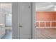 A door opens to reveal a bathroom with a shower/tub combination and an adjacent bedroom with orange walls at 411 Meadowood Blvd, Fern Park, FL 32730