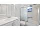 Well-lit bathroom with a vanity, mirrored cabinet, and enclosed shower and tub combo with a sliding glass door at 411 Meadowood Blvd, Fern Park, FL 32730