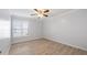 Light-filled bedroom features modern shutters, neutral paint, a ceiling fan, and wood-look flooring at 411 Meadowood Blvd, Fern Park, FL 32730