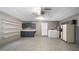 Spacious garage featuring laundry area, shelving, epoxy floor, and storage cabinets at 411 Meadowood Blvd, Fern Park, FL 32730