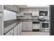Modern kitchen with stainless steel appliances, gray cabinets, granite countertops, and mosaic tile backsplash at 411 Meadowood Blvd, Fern Park, FL 32730