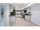 Well-lit kitchen featuring tile floors, granite countertops, stainless steel appliances, and gray cabinets at 411 Meadowood Blvd, Fern Park, FL 32730