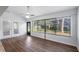 Bright room featuring wood floors, ceiling fan, large windows with blinds, and double doors at 411 Meadowood Blvd, Fern Park, FL 32730