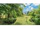 Spacious backyard featuring lush green grass and mature trees, offering privacy at 5203 Jasmine Trace Ln, Kissimmee, FL 34758