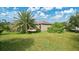 Lush backyard featuring mature palm trees and a well-maintained lawn at 5203 Jasmine Trace Ln, Kissimmee, FL 34758