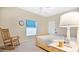 Cozy bedroom with a natural wood frame bed, a rocking chair, and a bright window at 5203 Jasmine Trace Ln, Kissimmee, FL 34758