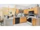 Efficient kitchen with light wood cabinetry, black appliances, and tile flooring, complemented by natural light at 5203 Jasmine Trace Ln, Kissimmee, FL 34758