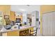 Bright kitchen with tile floors, a breakfast bar, and white appliances, adjacent to a storage or pantry area at 5203 Jasmine Trace Ln, Kissimmee, FL 34758