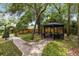 Charming backyard gazebo with seating, surrounded by lush landscaping and a brick pathway at 556 Lake Ave, Altamonte Springs, FL 32701