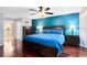 Main bedroom featuring a king bed, hardwood floors, blue accent wall, and ensuite bathroom at 556 Lake Ave, Altamonte Springs, FL 32701