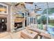Cozy sunroom with a stone fireplace, comfortable seating, and glass ceiling at 556 Lake Ave, Altamonte Springs, FL 32701