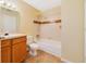 Bright bathroom featuring a sink vanity, toilet, and bathtub with tile surround at 6052 Westgate Dr # 204, Orlando, FL 32835