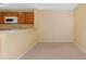 Cozy kitchen with white appliances, wood cabinets, and a breakfast bar open to the dining area with neutral colored walls at 6052 Westgate Dr # 204, Orlando, FL 32835