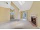Inviting living room featuring vaulted ceilings, skylights, a fireplace, and sliding glass doors leading to the balcony at 6052 Westgate Dr # 204, Orlando, FL 32835