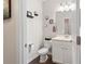 Half bathroom features modern fixtures, vanity, toilet, and wood-look floors at 6333 Schoolhouse Pond Rd, Winter Garden, FL 34787