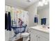 Bathroom features a modern vanity, toilet, mirror, and a fun patterned shower curtain at 6333 Schoolhouse Pond Rd, Winter Garden, FL 34787