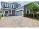 Beautiful two-story home with a charming porch and a brick driveway leading to the attached garage at 6333 Schoolhouse Pond Rd, Winter Garden, FL 34787