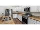 Modern kitchen featuring stainless steel appliances, granite countertops, and white cabinetry at 6333 Schoolhouse Pond Rd, Winter Garden, FL 34787