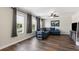 Bright living room boasts wood floors, large windows and a comfortable blue sofa at 6333 Schoolhouse Pond Rd, Winter Garden, FL 34787