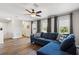 Cozy living room boasts wood floors, a ceiling fan, and a comfortable blue sofa at 6333 Schoolhouse Pond Rd, Winter Garden, FL 34787