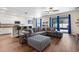 Stylish living room featuring a large sectional sofa, hardwood floors, and an open layout to the kitchen at 6333 Schoolhouse Pond Rd, Winter Garden, FL 34787