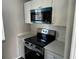 A close up of the kitchen with new stainless steel oven and microwave, and white cabinets at 652 Roaring Dr # 234, Altamonte Springs, FL 32714