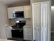 A close up of the kitchen with new stainless steel oven and microwave, and white cabinets at 652 Roaring Dr # 234, Altamonte Springs, FL 32714