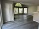 Open-concept living room with grey walls, wood-look flooring, large windows, and a closet at 652 Roaring Dr # 234, Altamonte Springs, FL 32714