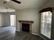 Living room showcasing a brick fireplace, grey walls, wood-look flooring, and natural light at 652 Roaring Dr # 234, Altamonte Springs, FL 32714