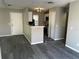 Living room view of a kitchen breakfast bar, white door, and wood-look floors at 652 Roaring Dr # 234, Altamonte Springs, FL 32714