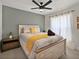 Comfortable bedroom with wood-look bedframe, ceiling fan, side table, and natural light from window at 703 Sunridge Woods Blvd, Davenport, FL 33837
