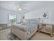 Bright bedroom features a ceiling fan, decorative dresser, and a comfortable bed with blue patterned linens at 703 Sunridge Woods Blvd, Davenport, FL 33837