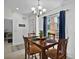 Dining room with wood table and chairs, bright natural light, and modern chandelier at 703 Sunridge Woods Blvd, Davenport, FL 33837
