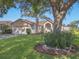 Charming single-story home featuring a well-manicured lawn, two car garage, and mature shade tree at 703 Sunridge Woods Blvd, Davenport, FL 33837