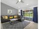 Open-concept living room with a large sofa, modern accents, and sliding glass doors at 703 Sunridge Woods Blvd, Davenport, FL 33837
