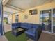 Covered outdoor living space with comfortable seating, outdoor TV and nice backyard views at 703 Sunridge Woods Blvd, Davenport, FL 33837