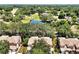 Aerial view highlighting community homes, a pond, and mature trees at 7521 Bay Port Rd # 12, Orlando, FL 32819